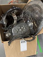 Photo showing stacked silver plate items including trays and what appears to be a sugar bowl or gravy dish inside a box.