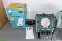 Image showing both the TP-Link Wi-Fi Range Extender in its box and the Heathkit Code Oscillator device side by side on a flat surface.