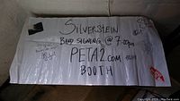 Full view of the white poster with "Silverstein Band Signing @ 7:00pm PETA2.com Booth" written in black marker and signed by band members, including a PETA sticker on the right bottom.