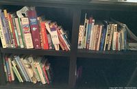 Bookshelf with assorted books including a dictionary, gardening books, and medical reference books.