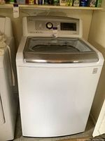 Front view of LG top-load washer showing control panel, glass lid and overall condition