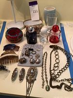 Overview photo showing Jo Malone fragrance bottles, jewelry pieces, hair combs, and decor items.