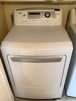 Front view of LG gas dryer showing door, lower lint drawer and full top surface.