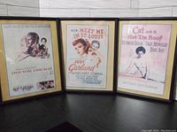 Three framed classic movie posters displayed side by side. Includes Doctor Zhivago, Meet Me in St. Louis, and Cat on a Hot Tin Roof. Black frames and beige mats surrounding each poster.