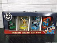 Full view of original boxed set with four pint glasses featuring DC Comics superheroes: Green Lantern, Wonder Woman, Batman, and Superman.