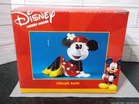 Red cardboard box with Disney Mickey Mouse branding, showing full image of the Minnie Mouse ceramic bank, labeled as ceramic bank.