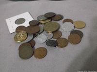 Coins spread on a surface showing a mix of gold, silver, and bronze tones.