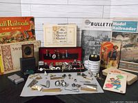 Overview of lot showing magazines on railroading and modeling, various men's accessories including cufflinks and tie tacks, a trade card book, and other vintage papers.