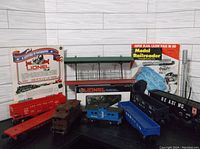 Full view of 8 Lionel train cars, station platform accessory, and train booklets including box packaging and Model Railroader magazine