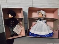 Two boxed Madame Alexander dolls, Betsy Ross and Laurie Little Men, shown with tags and original packaging.