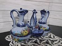 Front angled view of the full set showing two cruets and two small lidded compartments on crocheted lace mat.