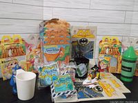 Wide shot showing vintage McDonald's Happy Meal items including Snow White and Dinosaur themed boxes, Batman bags, figurines, and cups