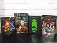 Four hardcover Star Wars books standing upright, front covers: The Force Awakens, Tatooine Ghost, Do Or Do Not There Is No Try (green Yoda silhouette), Cobalt Squadron