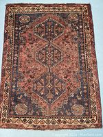 Full view of rectangular rug showing three central medallions and outer border