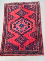 Overhead view of the full rug showing red field with navy geometric medallions and border