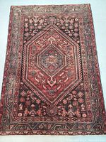 Overall front view of rug showing central medallion, border and field pattern