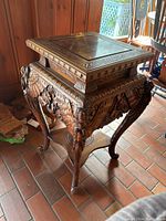 Front right angle view showing carved cabriole leg, claw foot, and floral carving on apron