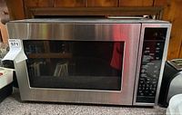 Front view of stainless steel convection microwave oven with large window and control panel on the right.