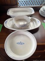 Set of four baking dishes on a table, showing Blue Cornflower design on white ceramic.