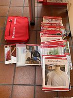 Husqvarna Viking embroidery discs, booklets, and red storage case arranged on floor