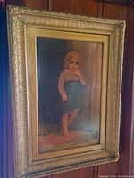 Full view of the framed vintage print featuring a young girl, showing the ornate gold frame and overall condition.