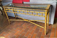 Side view showing rectangular shape, rattan frame with bamboo texture, and removable clear glass top.