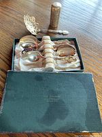 Box with six silver spoons placed inside with a decorative lighter behind the box.
