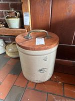 Front view of vintage Medalta 4 gallon stoneware crock with wooden lid and metal handle, showing '4' size mark and Medalta stamp.