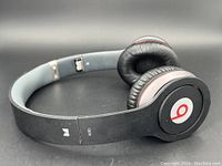 Beats Solo 2 wired on-ear headphones in black, showing headband and ear cup with red 'b' logo.