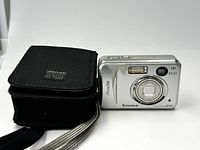 Front view of silver FujiFilm FinePix A345 digital camera beside black Denali carrying case