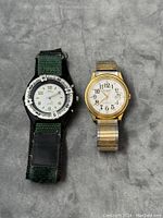 Two unisex wristwatches side by side: left is Boca Classics diver watch with fabric and leather strap, right is Helbros quartz watch with gold-tone expandable metal band.