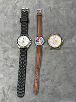Three Disney character wristwatches placed side by side showing full length and design, including straps and watch faces.