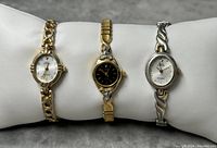 Three Sarah Coventry ladies quartz watches displayed on padded holder, showing front faces and bands