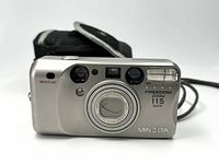 Front view of Minolta Freedom Zoom 115 camera showing lens, flash, and branding.