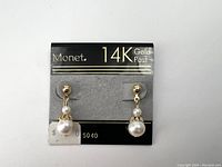 Front image showing the pair of Monet earrings on the original gray display card labeled 14K Gold Post.