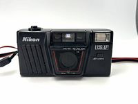 Front view of Nikon L135AF camera showing lens, flash, ISO dial, and Nikon branding.