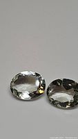 Close-up of two oval cut light teal prasiolite gemstones with high clarity.
