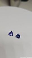 Two trillion cut tanzanite gemstones on a white background showing colors and shape