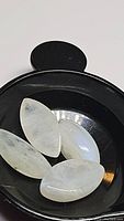 Four natural marquis cabochon rainbow moonstones in a black tray showing translucency, blue flash, and inclusions.