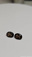 Pair of oval cut smokey quartz gemstones on a flat white surface showing their size and shape.