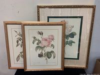 Three framed floral prints from Bombay Company featuring Pierre-Joseph Redouté reproductions, arranged with two smaller in front and one larger in back