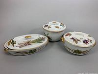 Three vintage Royal Worcester Evesham covered porcelain cookware pieces displayed side by side showing their lids and overall decoration.