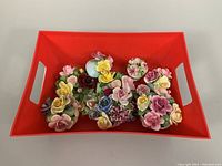 Top view of six assorted bone china floral bouquet figurines in red tray showing detailed flower arrangements and colors.