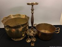Set of vintage brass planters and candleholders shown against plain background.