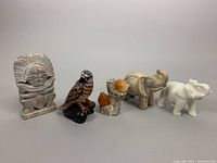 Front view of all five handcrafted stone sculptures: Aztec man god of fire, selenite carved birds on marble stone, hand painted hawk and two elephants.