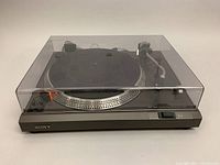 Turntable system with closed dust cover showing front profile and control elements.