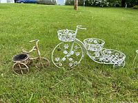 Two bicycle plant holders on grass showing size comparison and overall design.