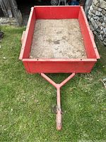 Front view showing tongue with ball-coupler hitch and red steel sides