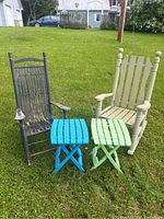 View of both rocking chairs and two folding tables on grass with a house and car in background