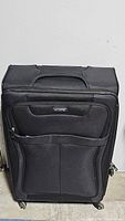 Front view of a large black Samsonite soft suitcase with front pocket and handle.